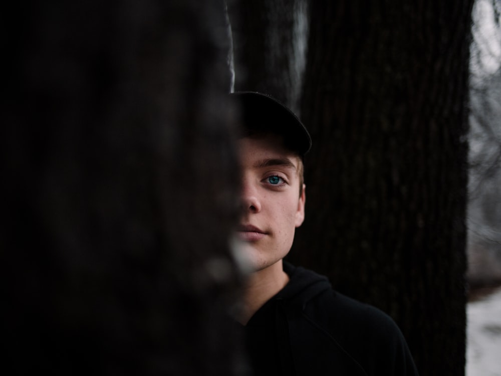 selective focus photography of person wearing black shirt and black hat