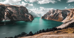 body of water between brown mountains