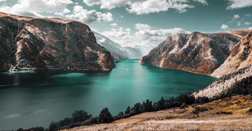 body of water between brown mountains