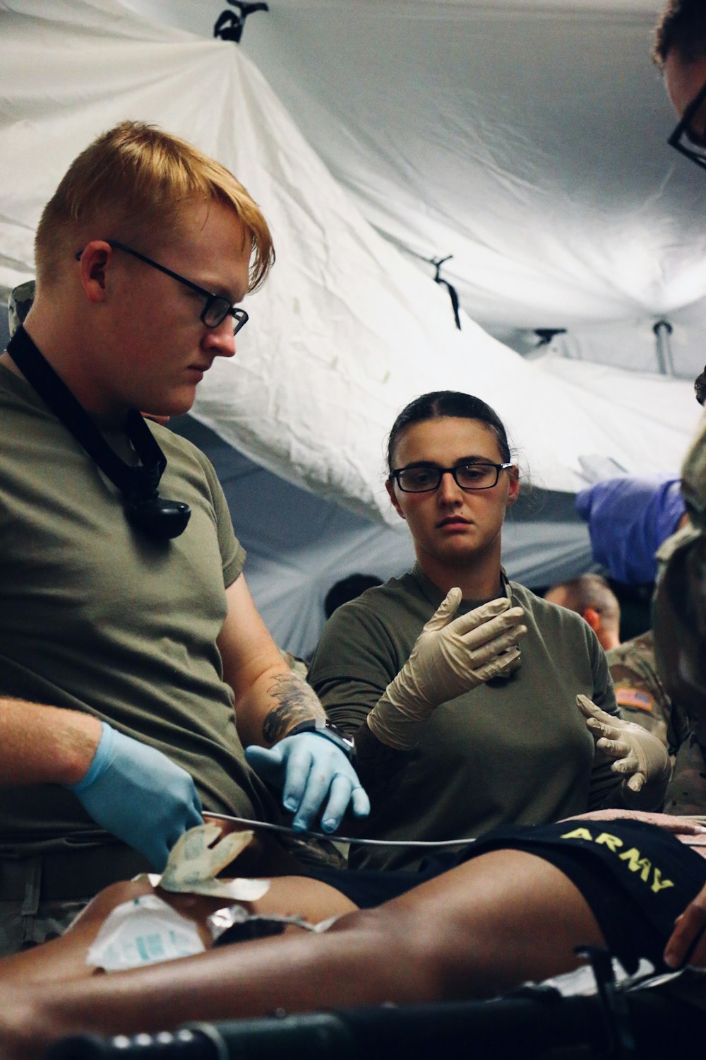 selective photography of two military medics near patient on stretcher