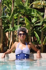 woman leaning on concrete near banana trees