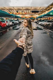 man and woman walking near parking lot take me there photography