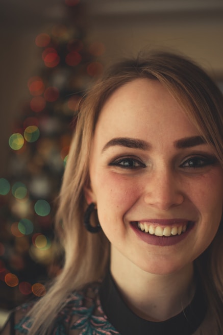 A close-up of a confident woman with playful lighting, inviting interaction.