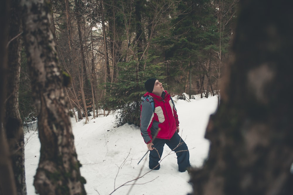 man walking on snow near trees during daytime