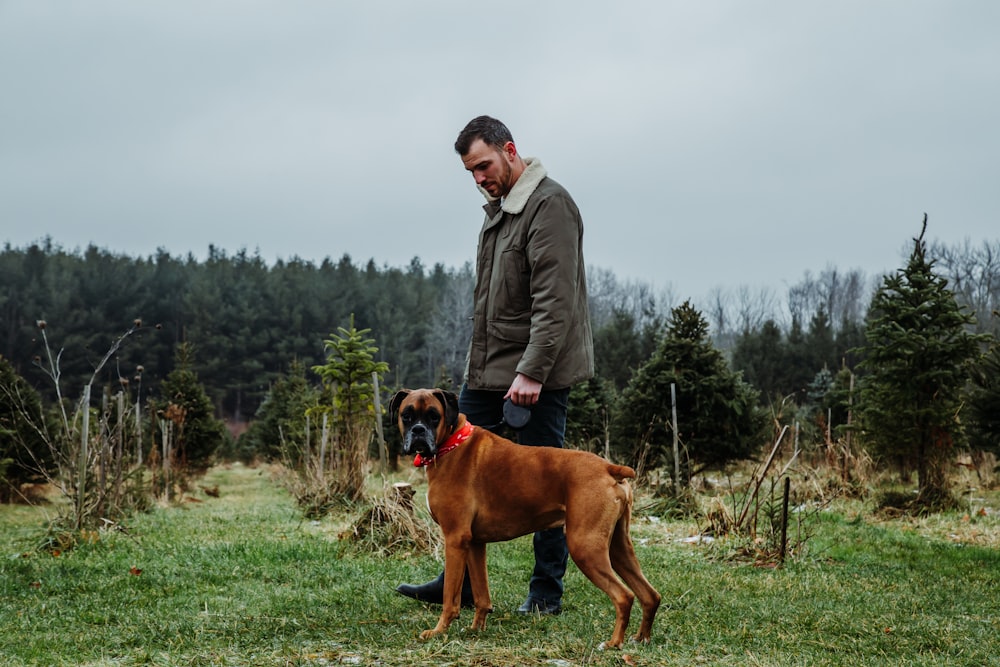 man beside tan dog