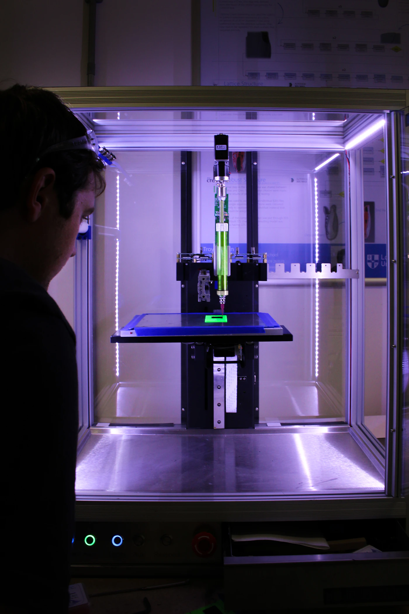A person examining a 3D printer in a workshop