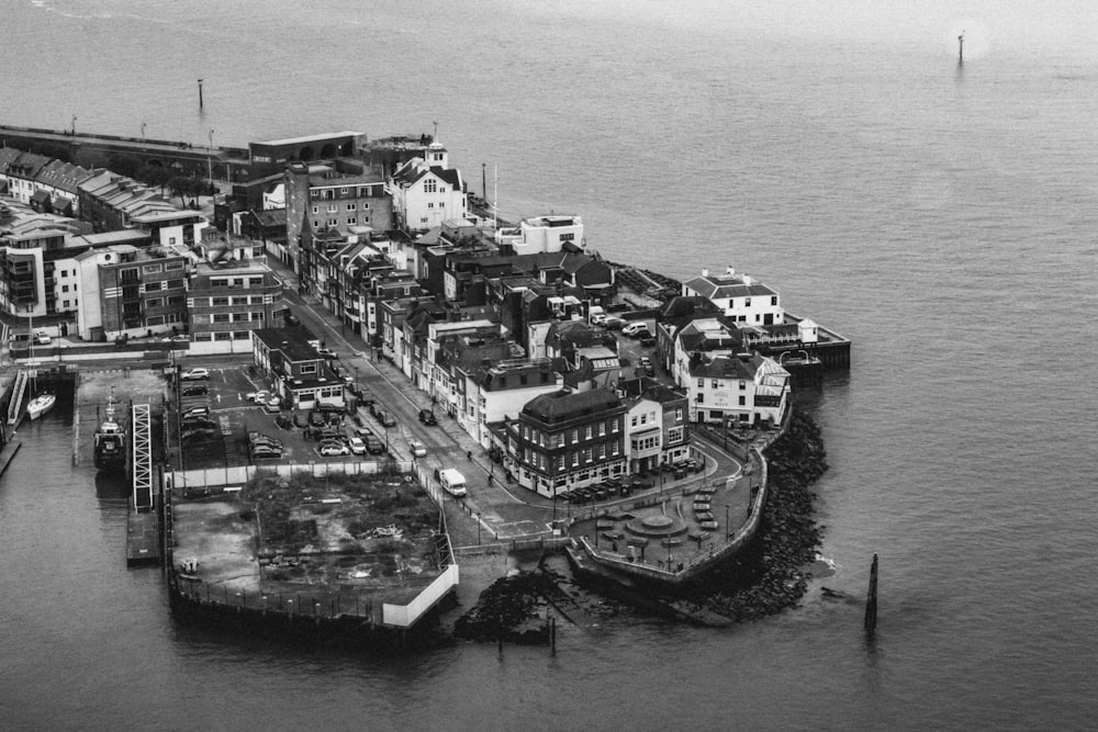 grayscale photography of buildings beside body of water