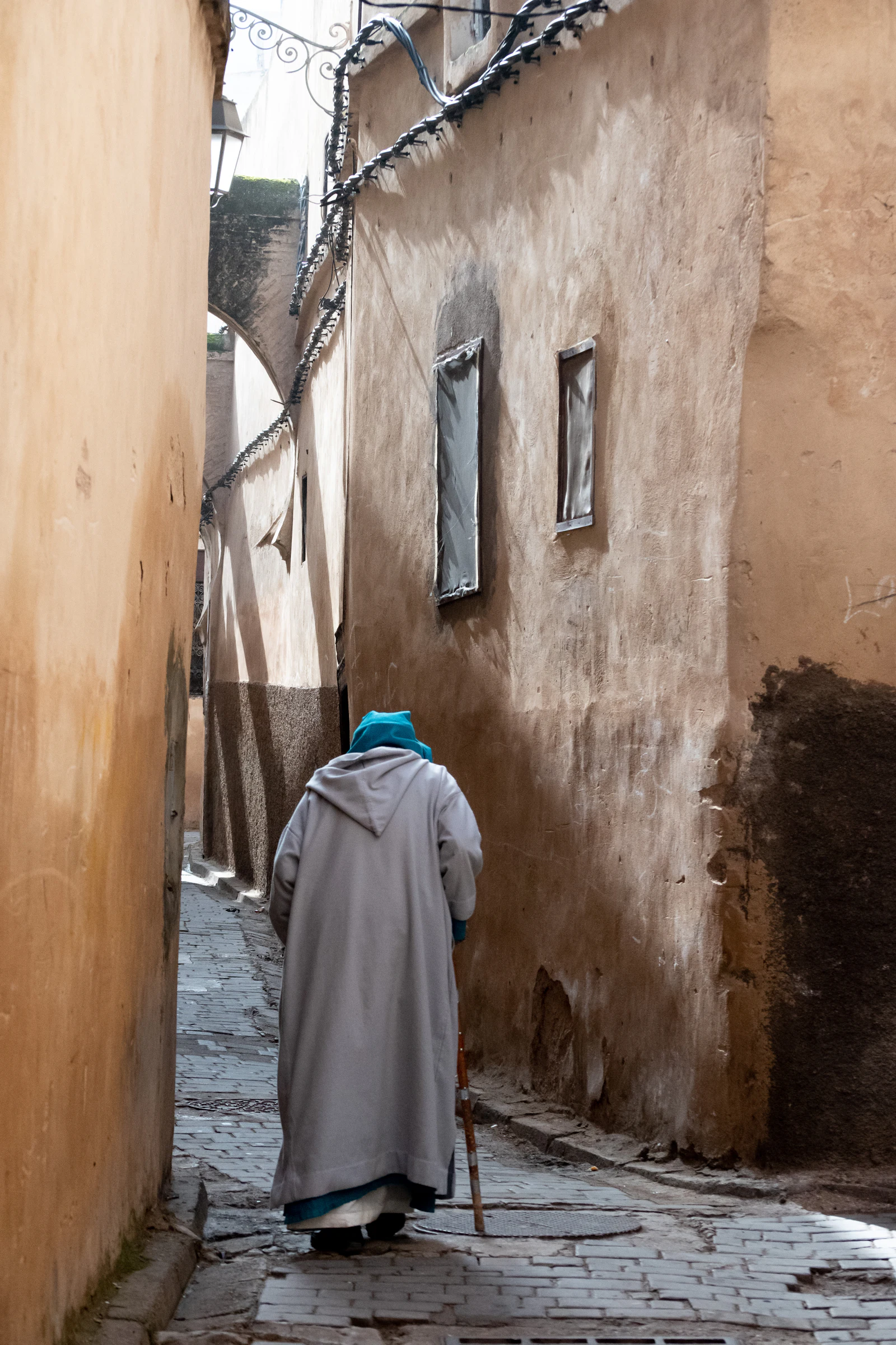 A man walks through a narrow old-town alley in Morocco.