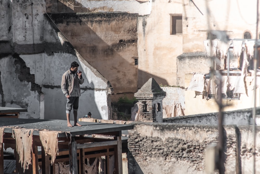 man standing near brown concrete building