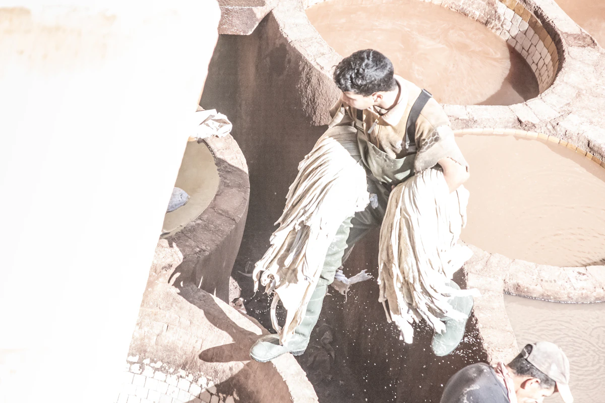 Tanneur travaillant le cuir dans les bassins traditionnels de la tannerie Chouara à Fès, artisanat séculaire