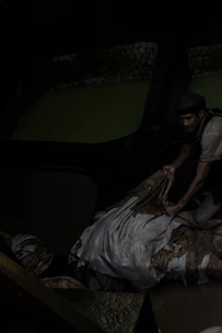 Skilled technician inspecting rexine texture under bright factory lights.