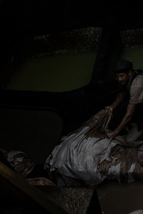 A worker inspecting and sealing exotic leather packages before export