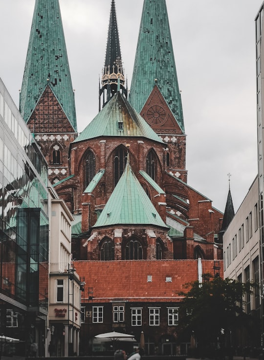 orange and teal building under white clouds in St. Mary's Church, Lübeck Germany