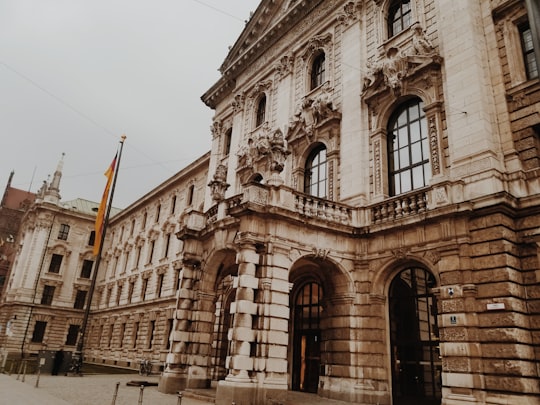 brown concrete building with orange flag in front during daytime in Hofgarten Germany