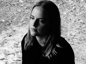 Portrait of Laura Summers Davis in a serene outdoor setting near Helper, Utah, holding a vintage spirit board.