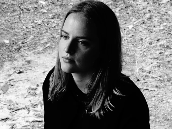 Portrait of Laura Summers Davis in a serene outdoor setting near Helper, Utah, holding a vintage spirit board.