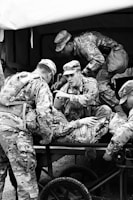 Group of UK armed forces members practicing first aid on a simulated casualty.