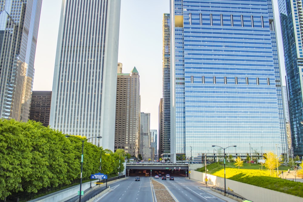 aerial photography of vehicles passing on tunnel under high-rise buildings during daytime