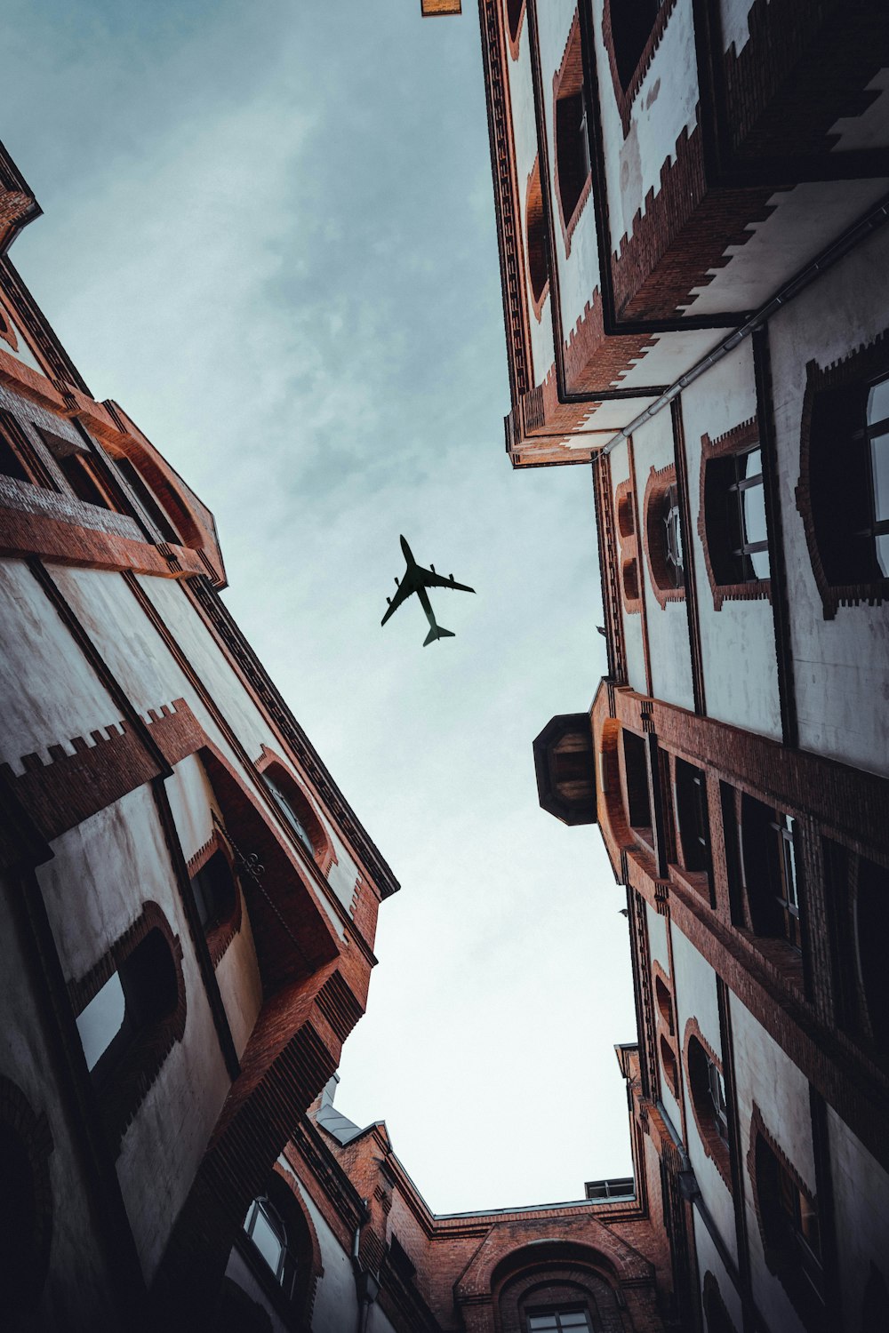 airplane over white buildings