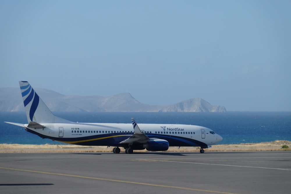 white and blue airplane near body of water