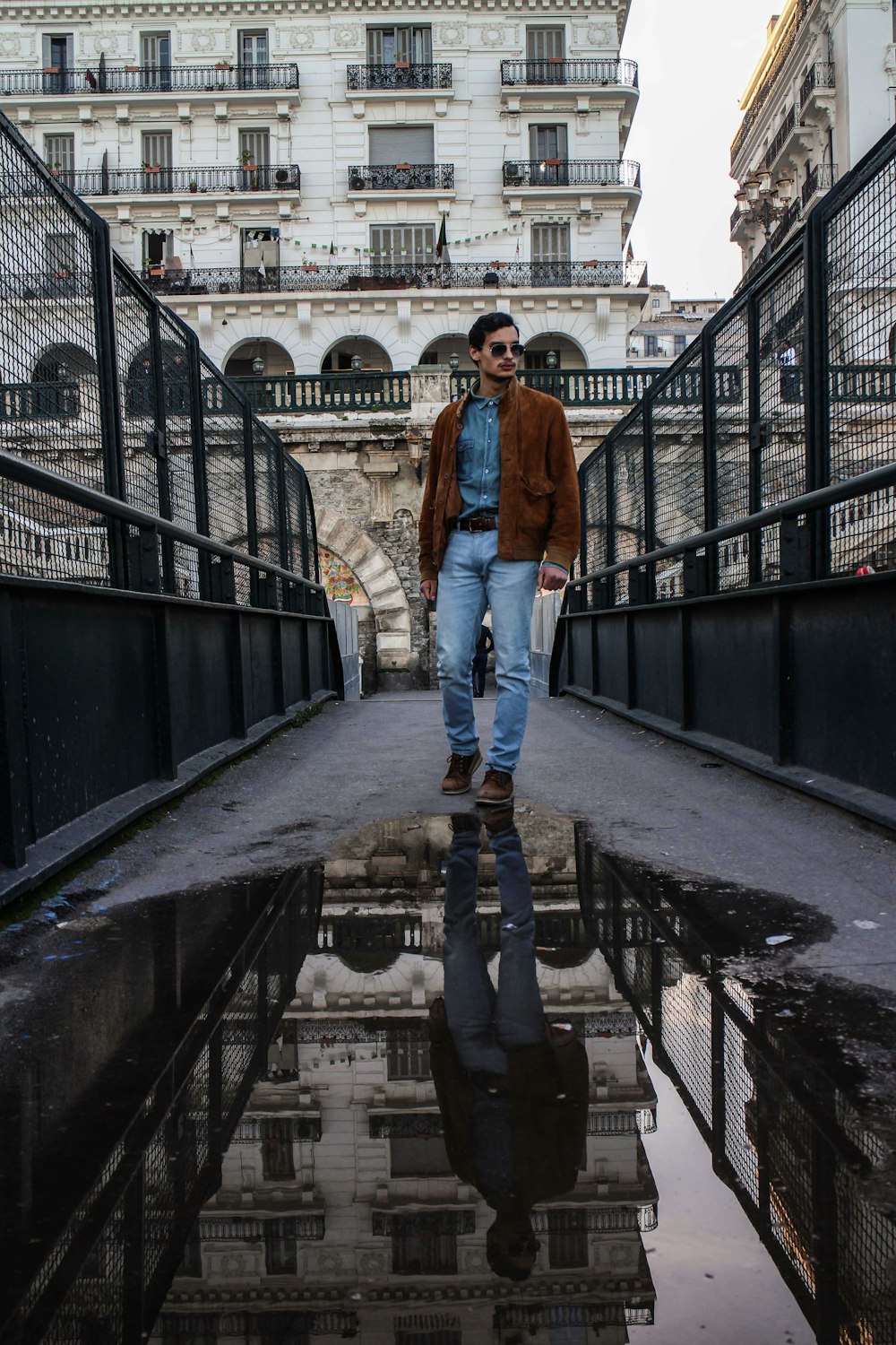 man standing at middle of bridge