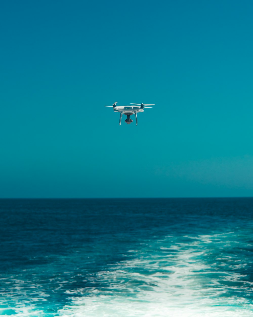 drone flying above sea during daytime