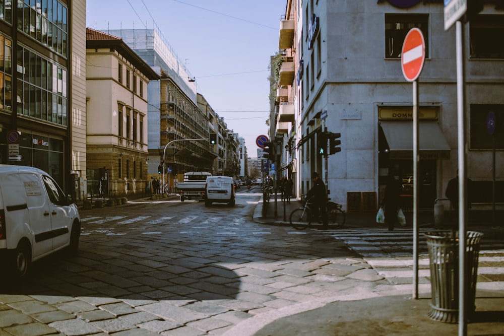 cars passing by buildings during daytime