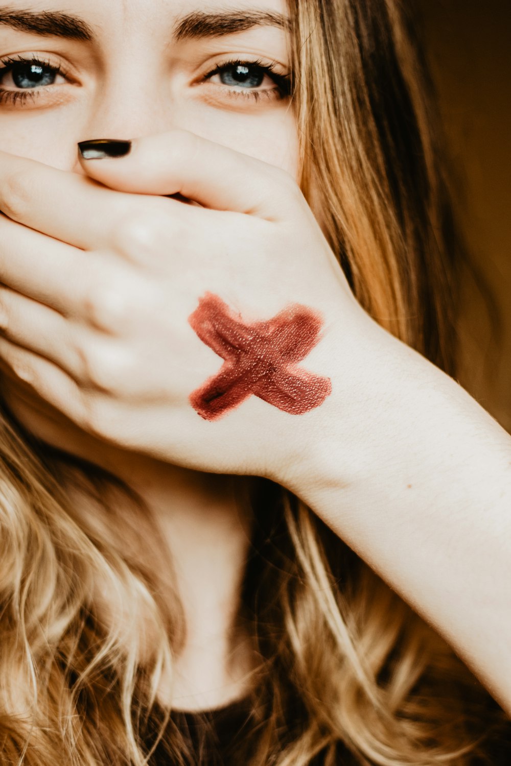 woman cover her mouth with her left hand