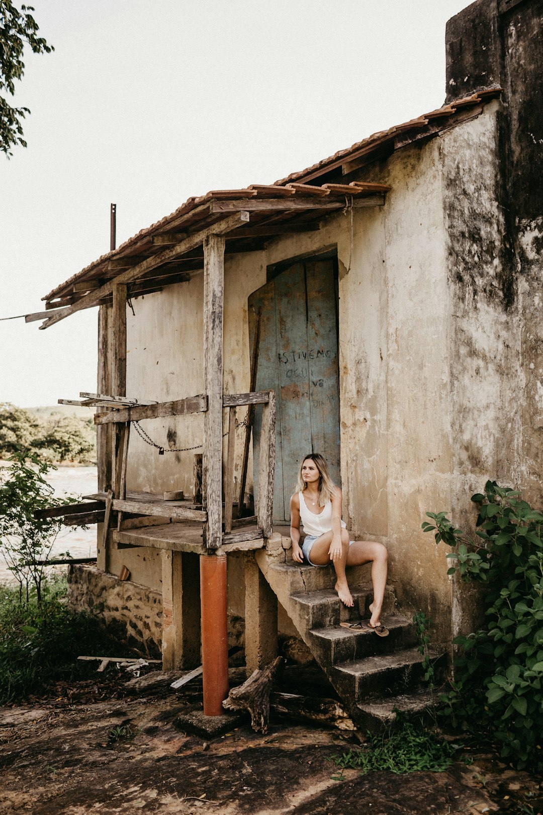 woman sitting on stairs beside house during daytime