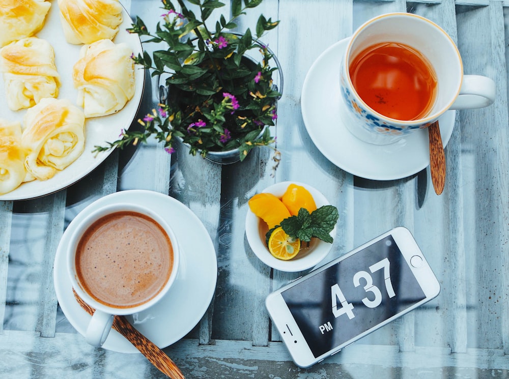 smartphone beside cup