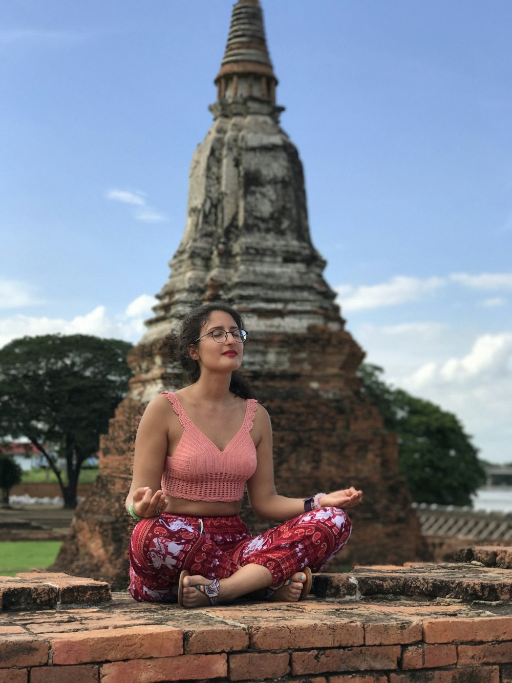 mujer haciendo postura de yoga al lado de un hito