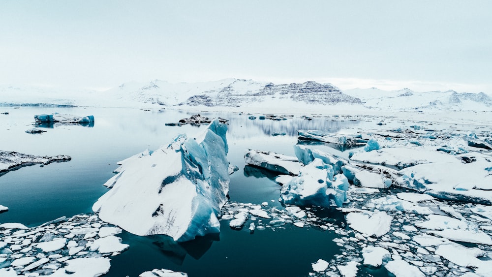 iceberg near mountains during daytime