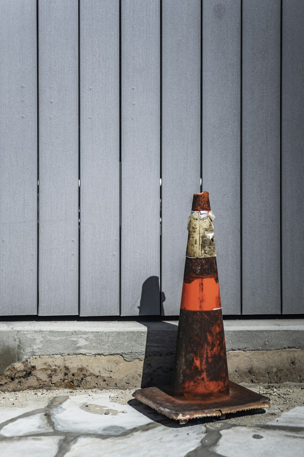 traffic cone beside wooden fence