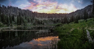 A serene landscape showing a group of travelers enjoying a peaceful sunset by a lake.