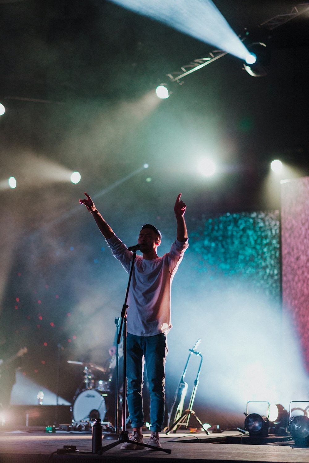 man singing on stage at night-time