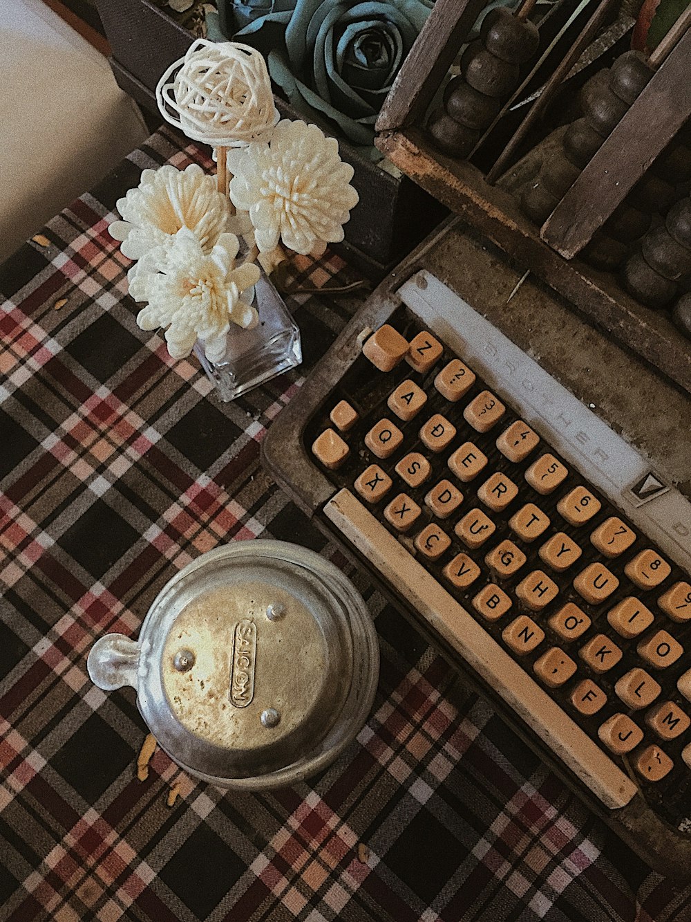 white flower centerpiece beside typewriter