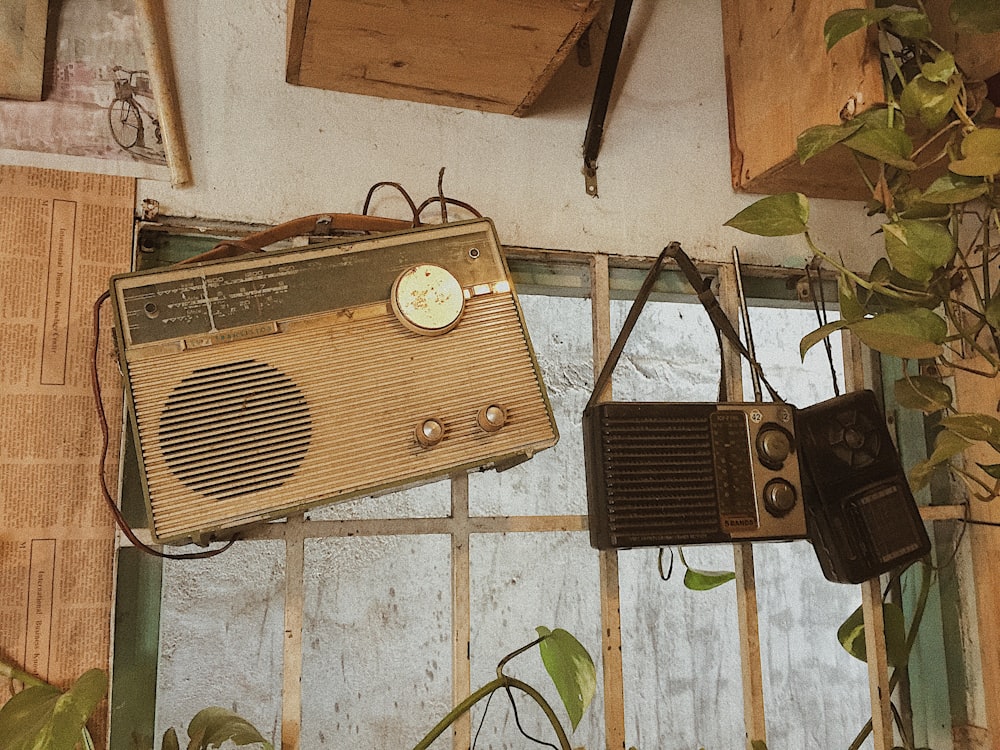 three assorted-color radios hang on wall