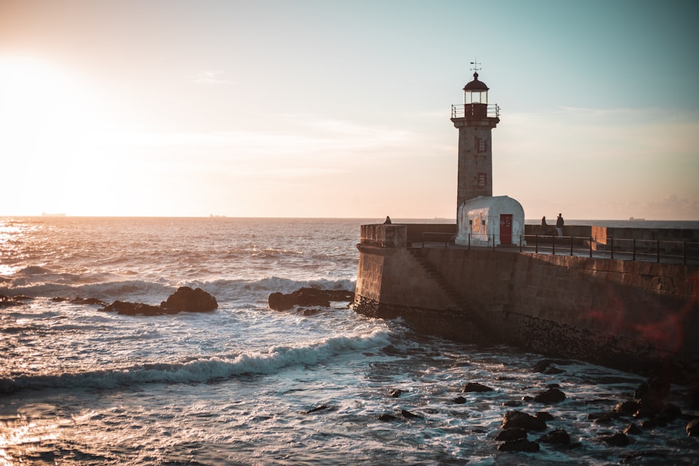 sea waves crashing on lighthouse