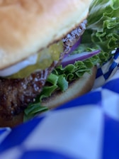 Close-up of a juicy hickory smoked burger with a caramelized crust on a toasted bun.