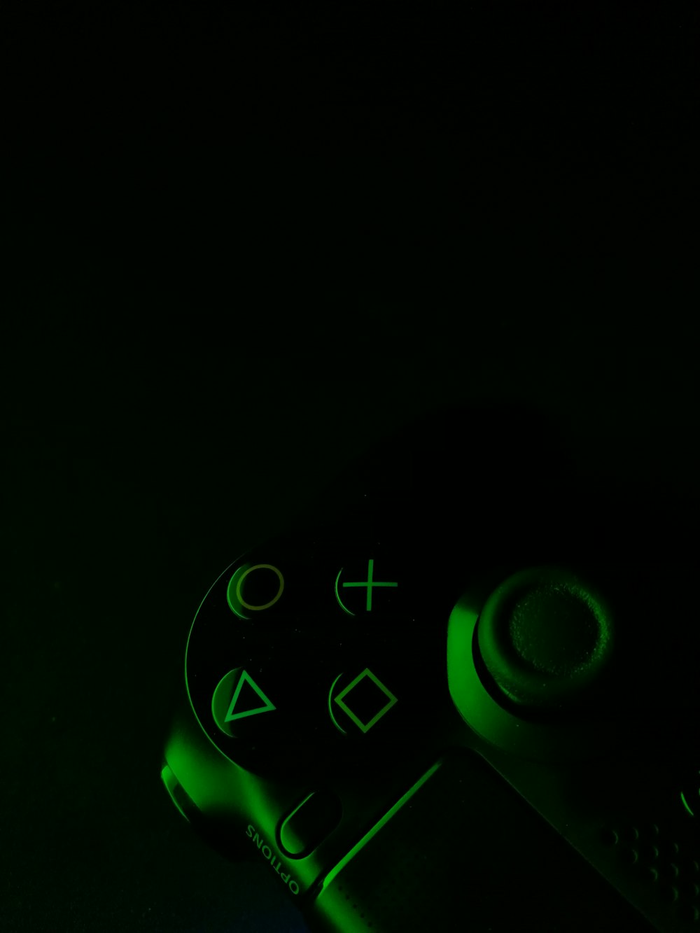 green and black game controller in dimmed light