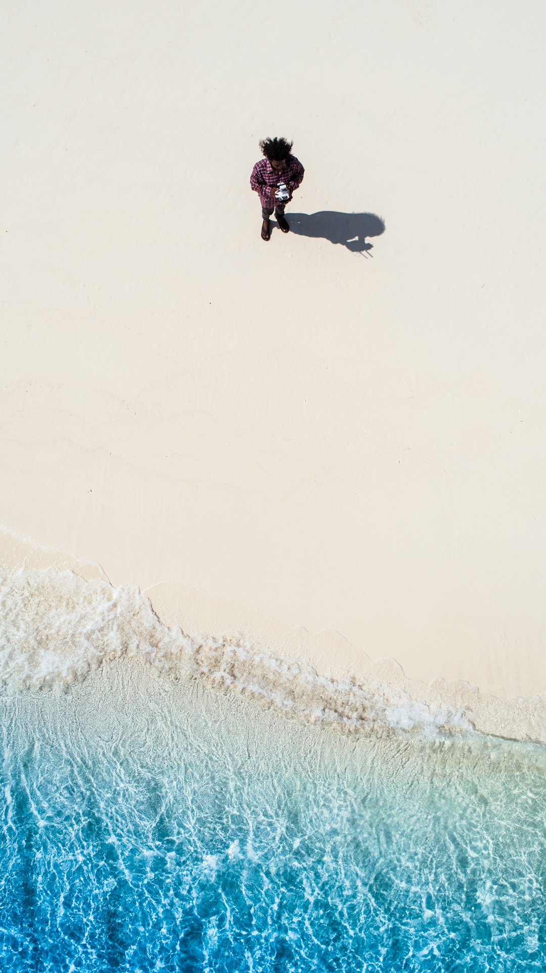 person standing and facing body of water at daytime