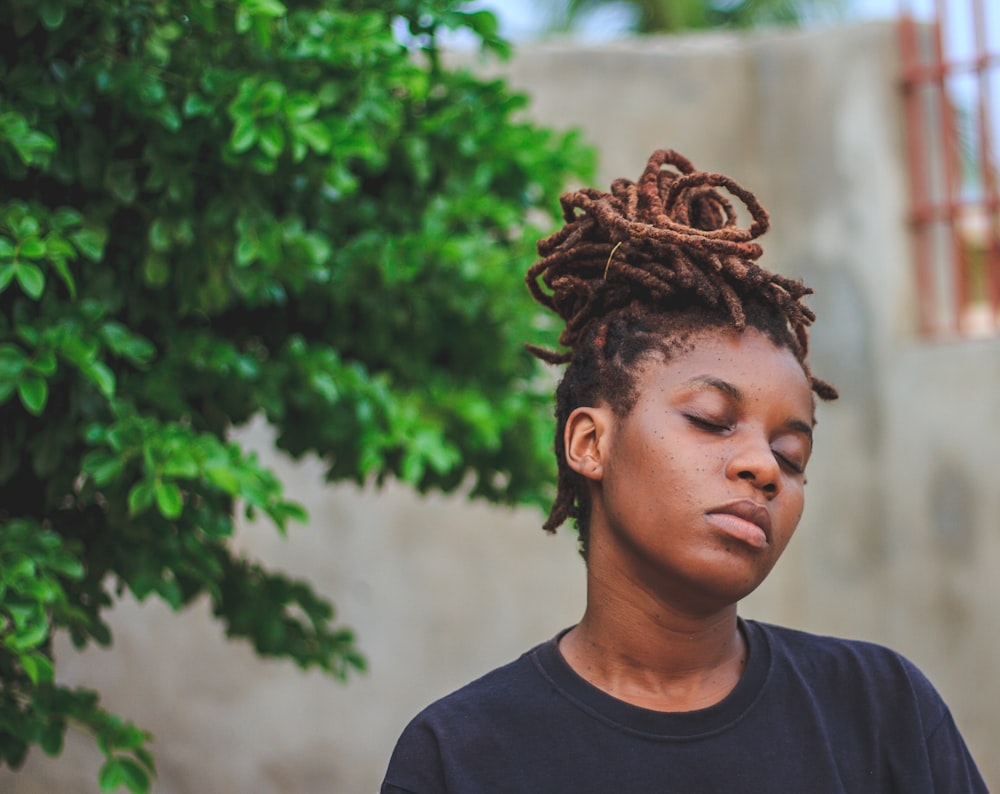 woman wearing black crew-neck shirt near green trees