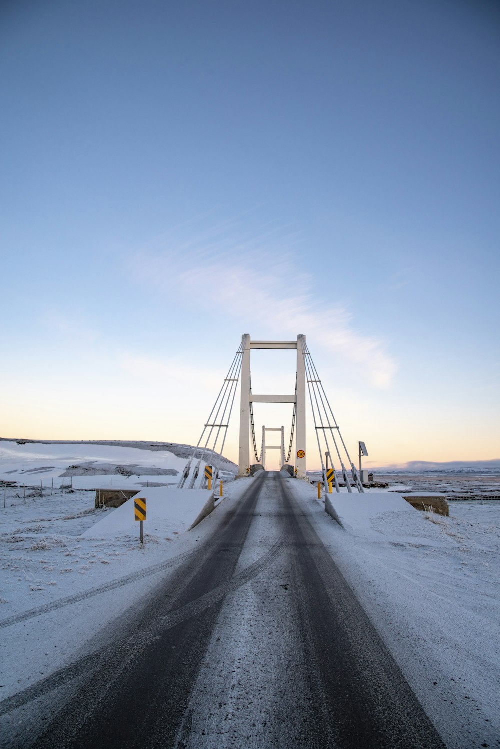 empty suspension bridge under white skies