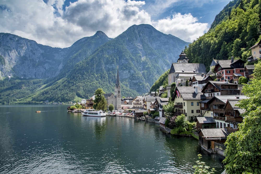 white motorboat in body of water near the mountain during daytime