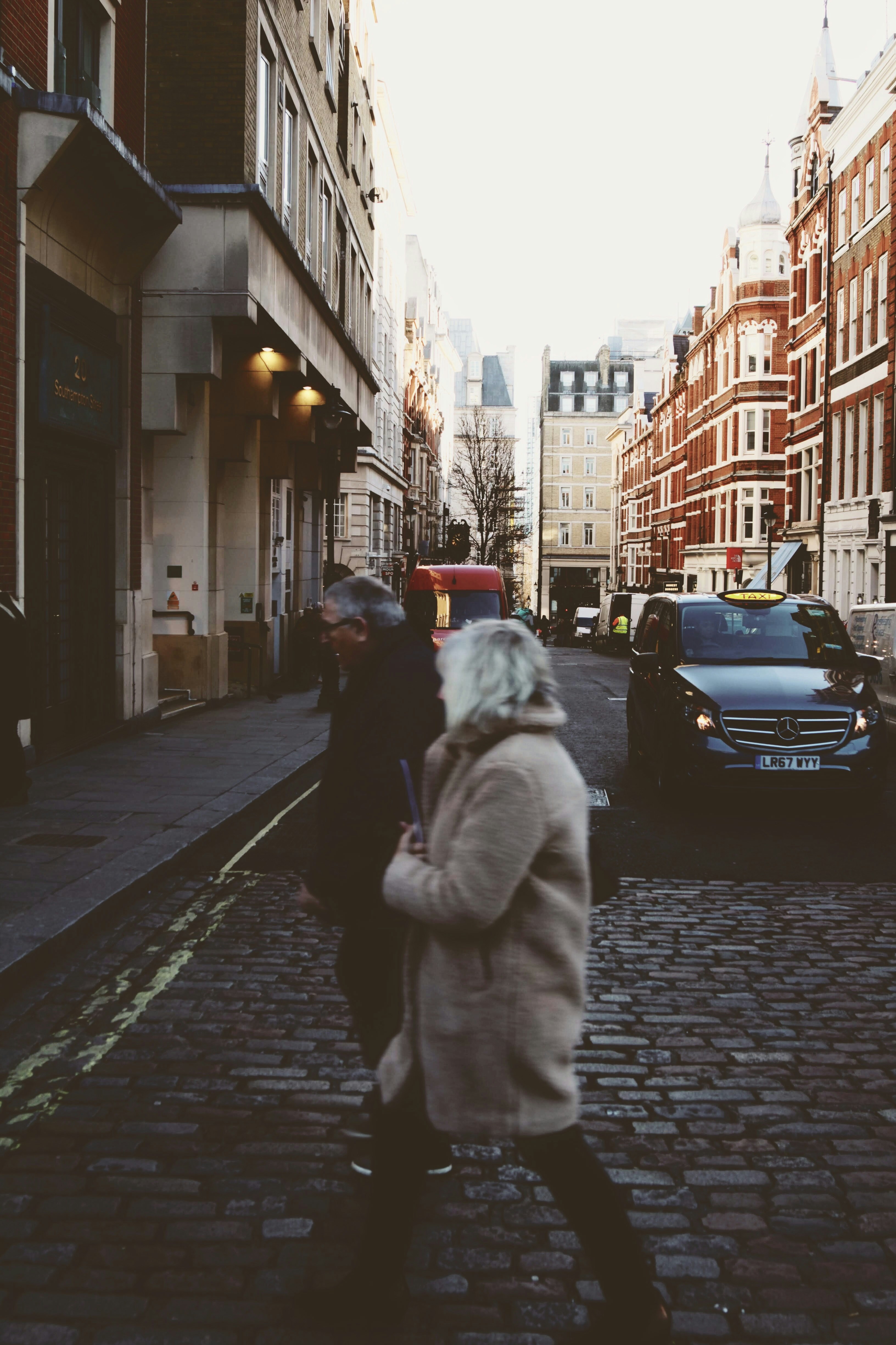 two man and woman walk in road during daytime
