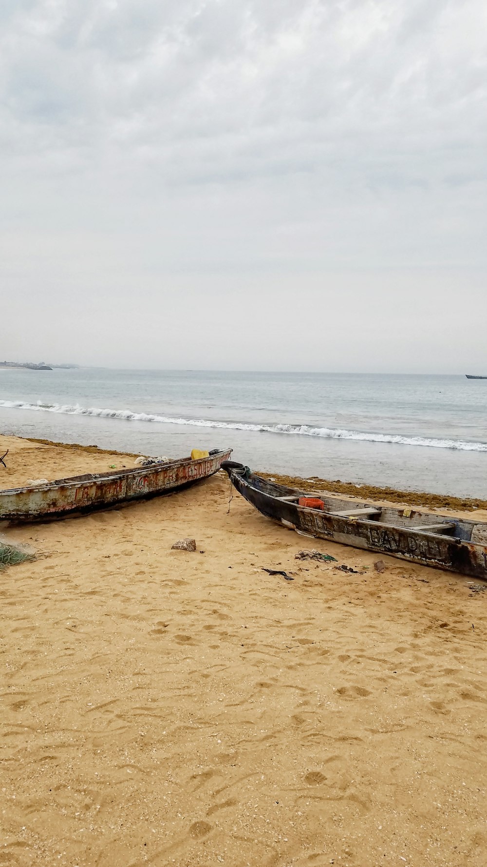 two black paddle boats on seashore during daytime