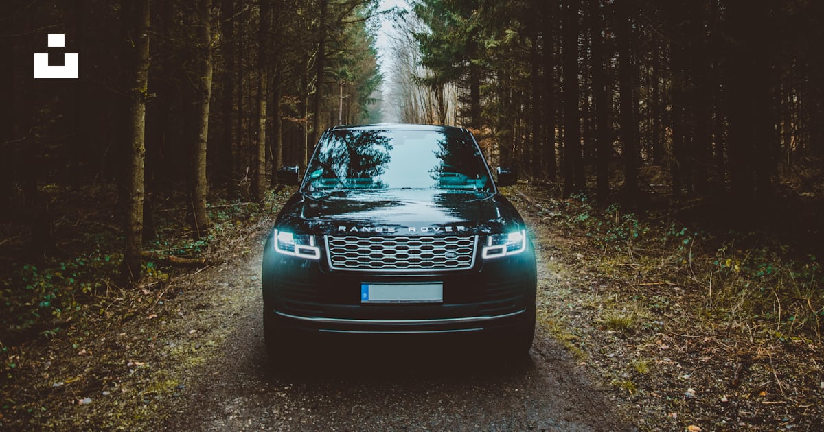 Verde Land Rover Range Rover SUV passando em estrada de terra entre ...