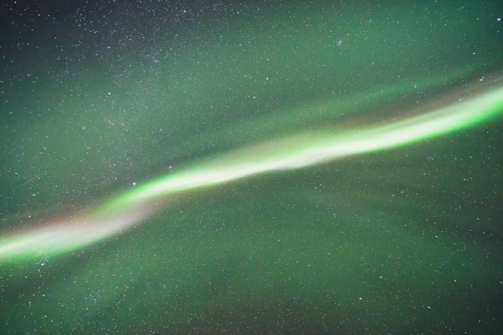 a green and white aurora bore in the night sky