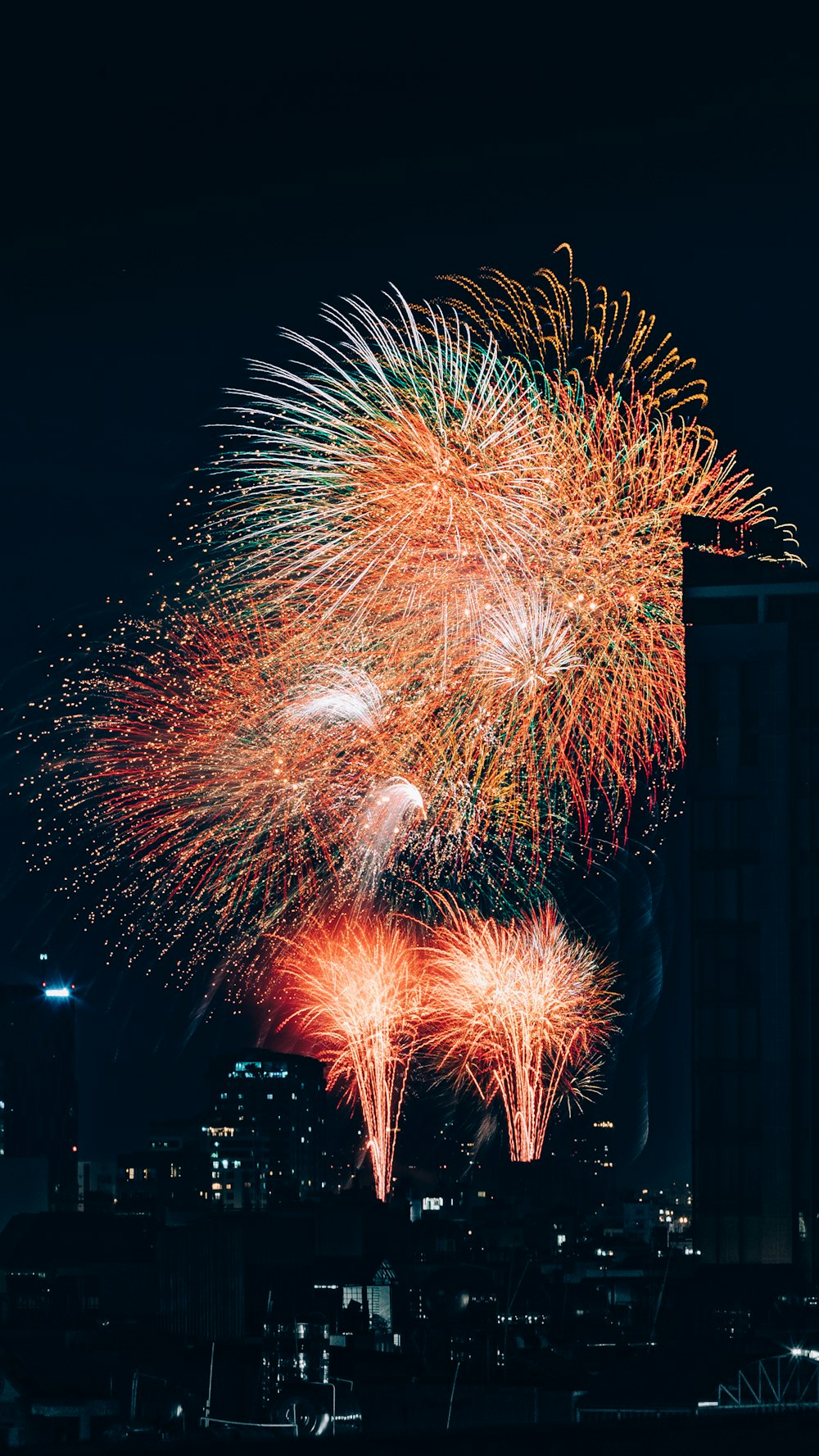 a fireworks display in the night sky over a city