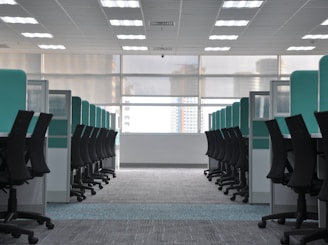 empty black rolling chairs at cubicles